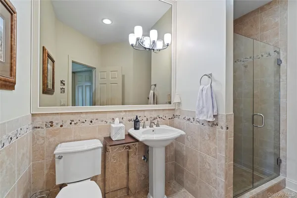 a bathroom with a sink a toilet and shower