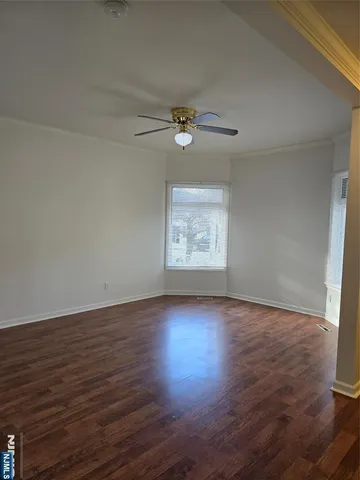 an empty room with wooden floor air conditioner and windows