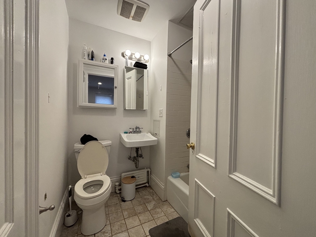 98 Charles Street, Unit 1 Boston, MA 02114 - Photo 6 of 9 a bathroom with a toilet a sink and mirror