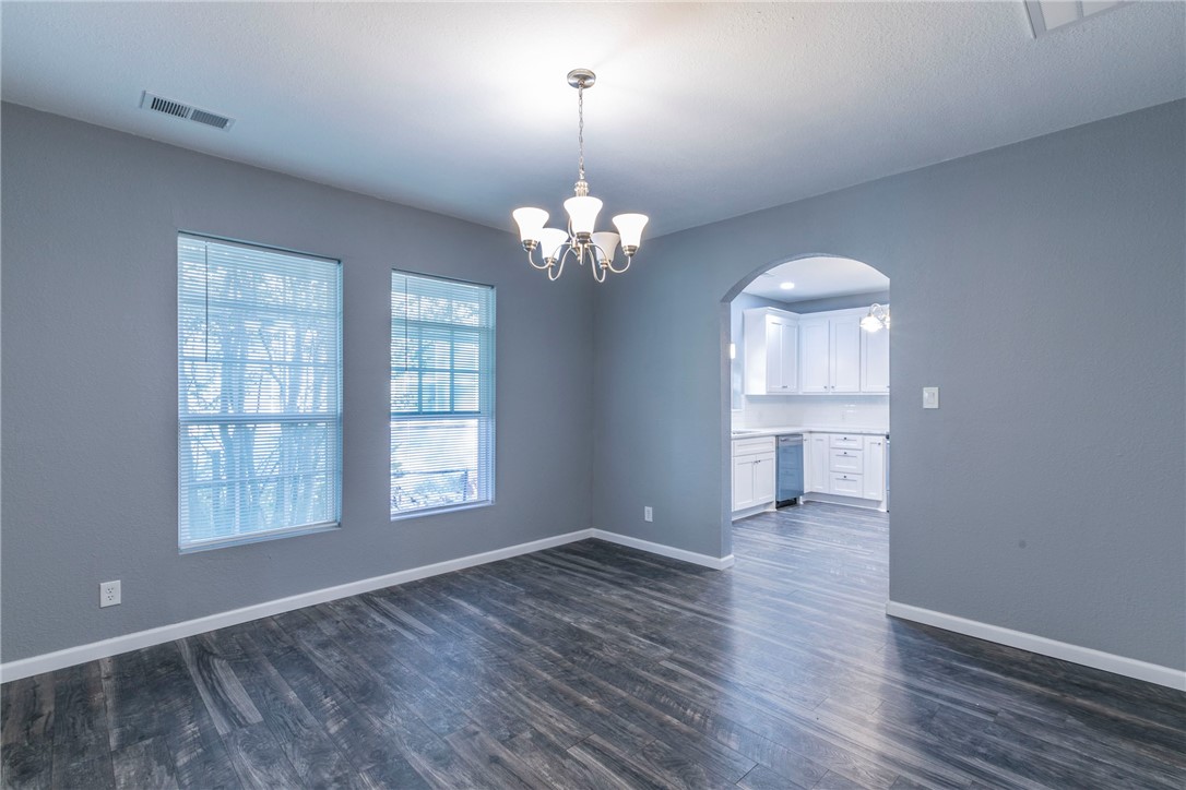 1007 North 22nd Street Waco, TX 76707 - Photo 8 of 26 an empty room with wooden floor chandelier and windows