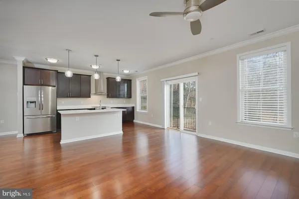 a large white kitchen with kitchen island a sink stainless steel appliances and cabinets
