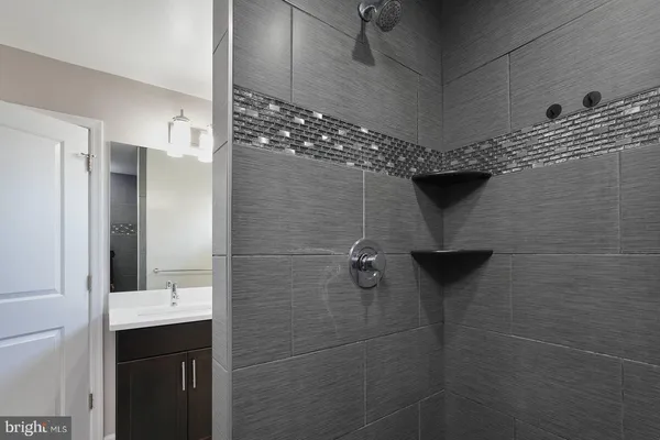 a bathroom with a sink shower and a mirror