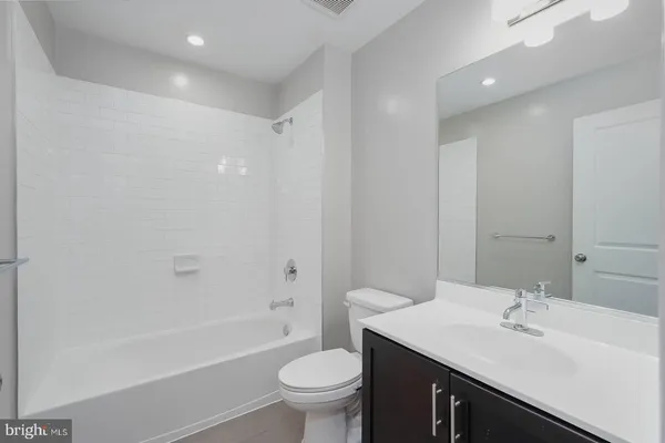 a bathroom with a sink a toilet a mirror a vanity and shower