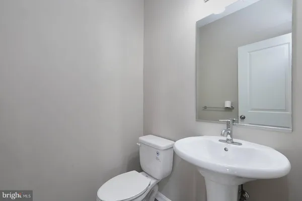 a bathroom with a sink a toilet and mirror