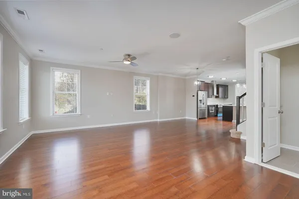 a view of empty room with wooden floor and windows