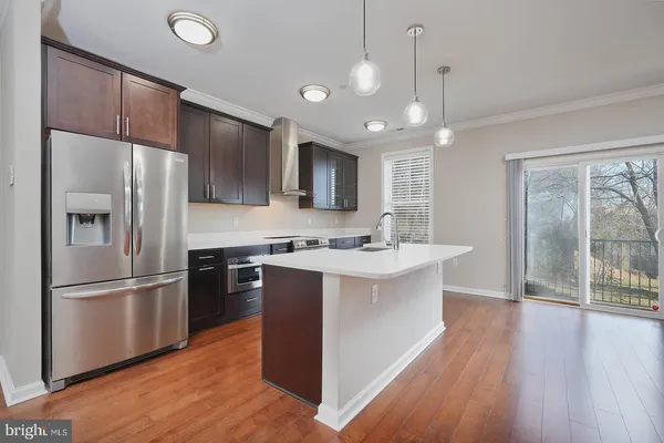 a kitchen with kitchen island a counter top space a sink appliances and cabinets