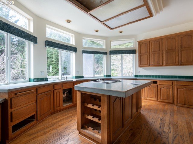 65477 Elk Ridge Road North Bend, OR 97459 - Photo 10 of 32 a kitchen with granite countertop a sink and wooden cabinets