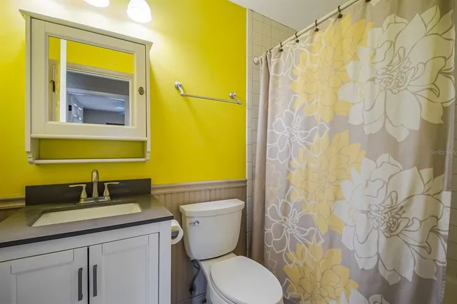 a bathroom with a granite countertop sink toilet and shower