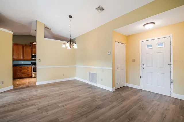 wooden floor in an empty room with a kitchen