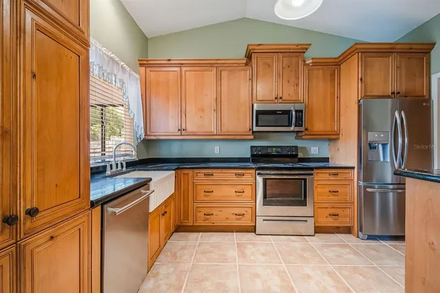 a kitchen with granite countertop stainless steel appliances and refrigerator