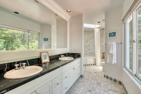 a spacious bathroom with a granite countertop sink and a mirror