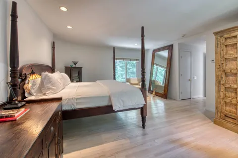 a bedroom with bed and wooden floor