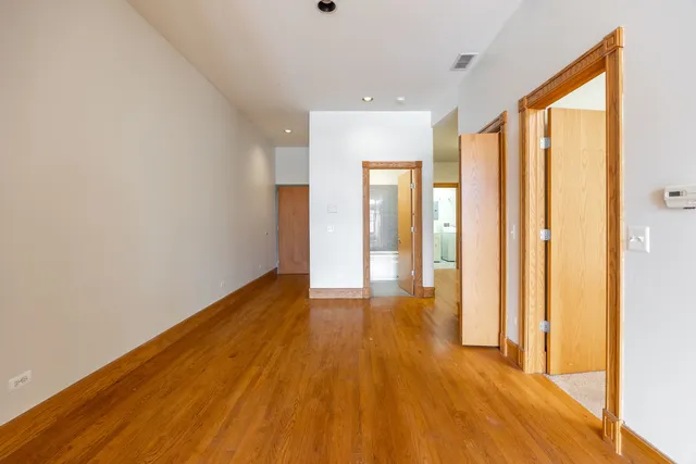 a view of a big room with wooden floor and windows