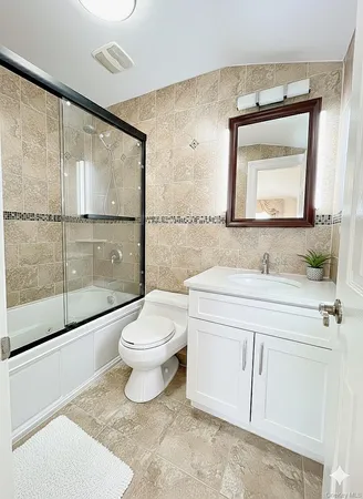 a bathroom with a toilet a sink a mirror and a shower