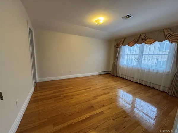an empty room with wooden floor closet and a bathroom
