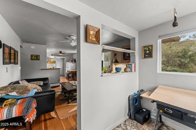 a view of a workspace with furniture and a window