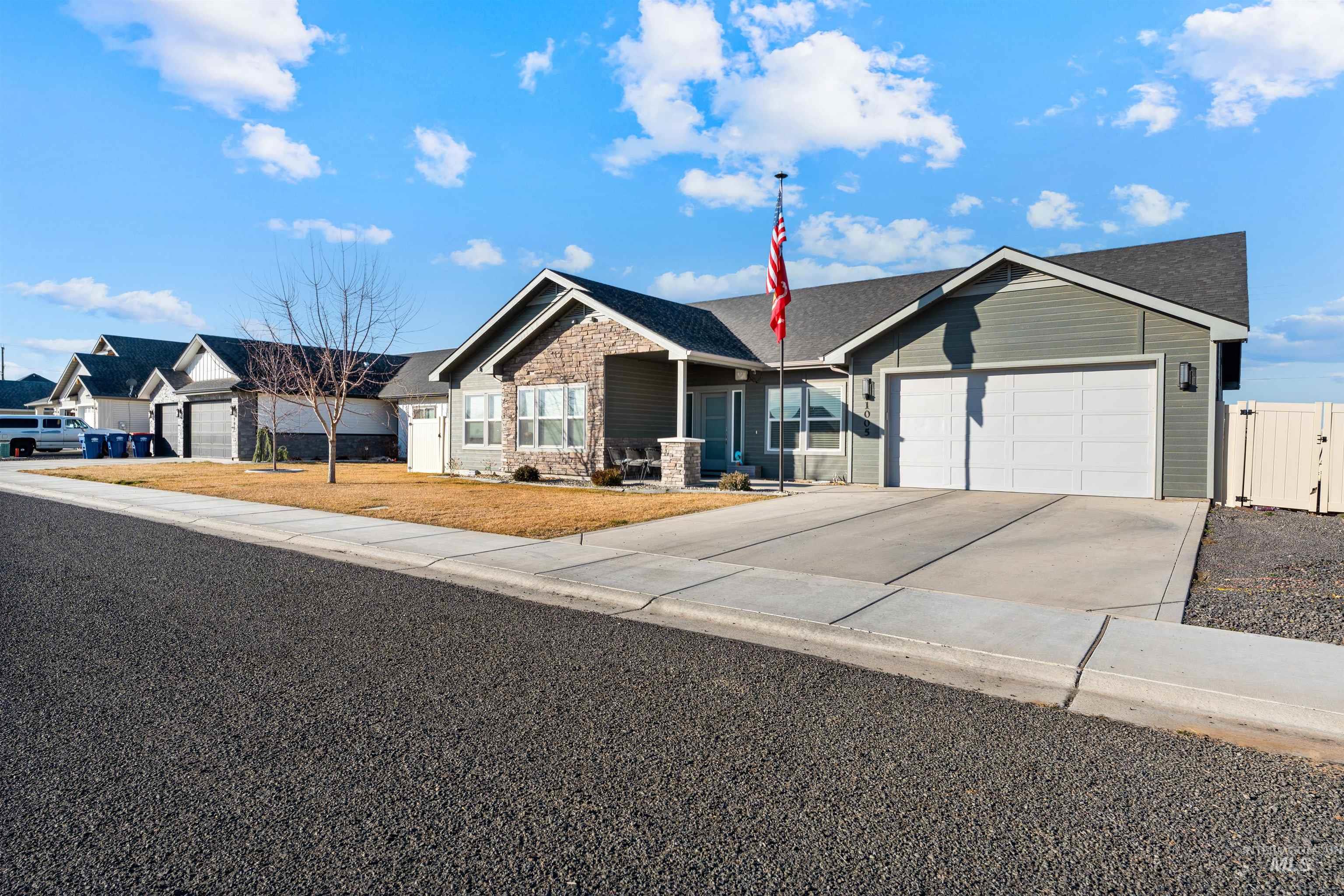 1005 Kenbrook Loop Twin Falls, ID 83301 - Photo 2 of 47 Ranch-style home with driveway, an attached garage, stone siding, a porch, and a gate