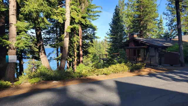 a front view of a house with a yard and tree s