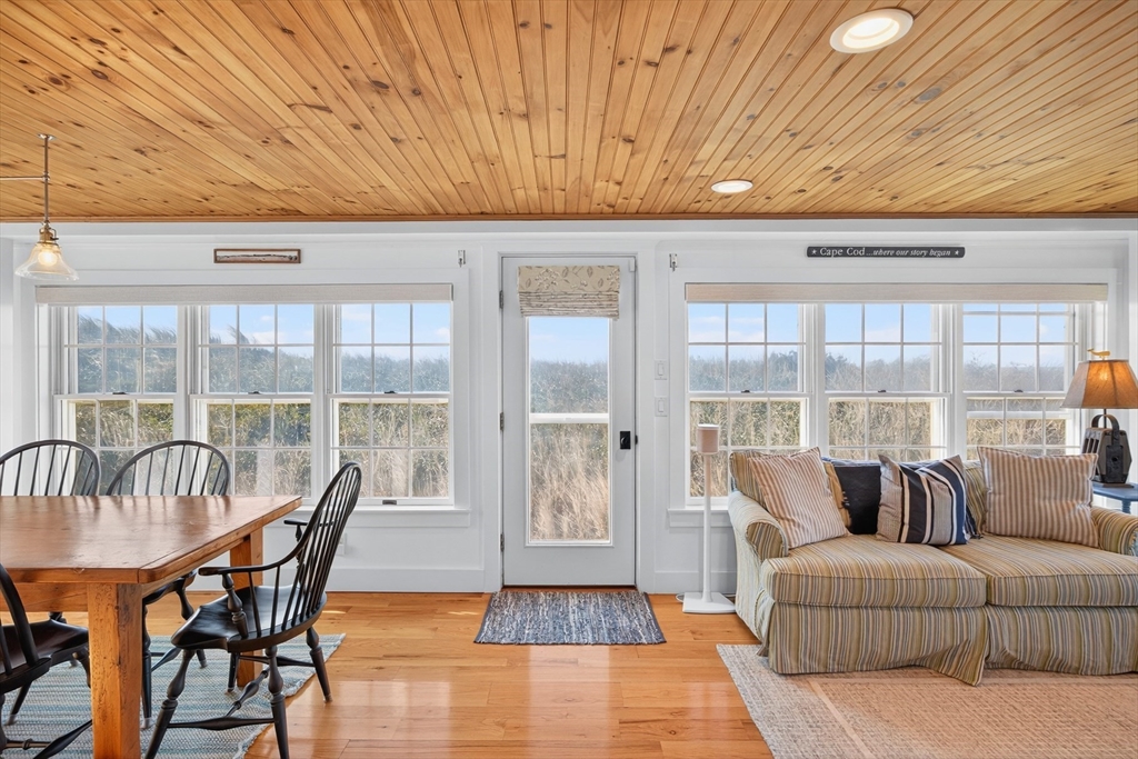 1145 Kingsbury Beach Road Eastham, MA 02642 - Photo 23 of 42 a living room with furniture and large windows