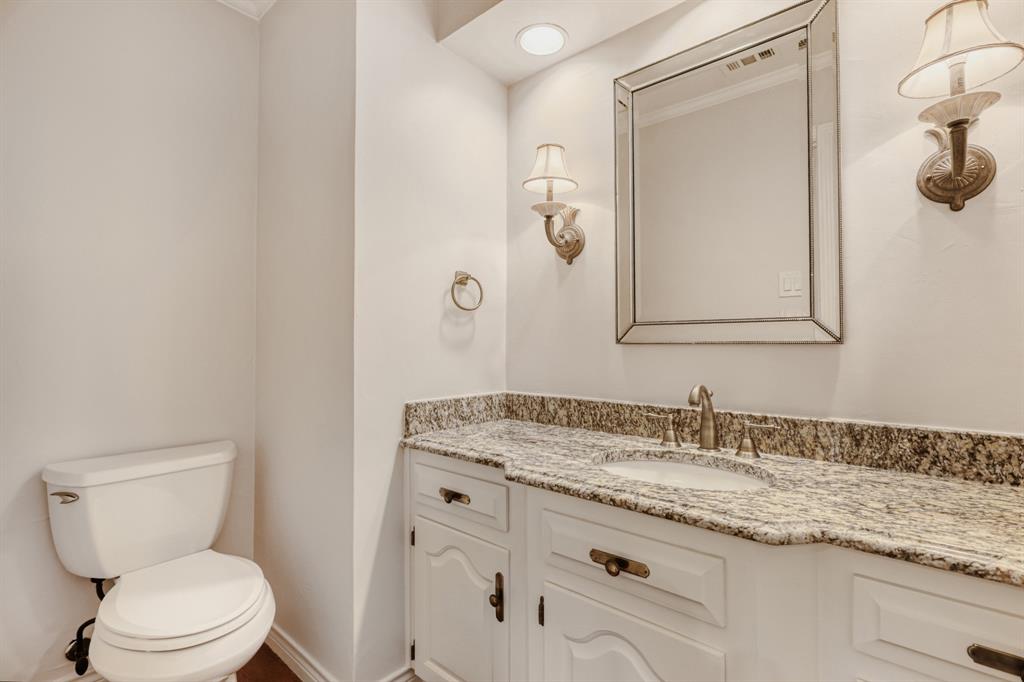 6108 Bluff Point Drive Dallas, TX 75248 - Photo 17 of 28 a bathroom with a granite countertop toilet sink and mirror