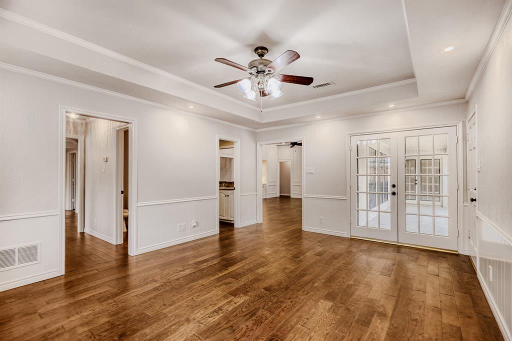 6108 Bluff Point Drive Dallas, TX 75248 - Photo 23 of 28 a view of an empty room with wooden floor and a ceiling fan