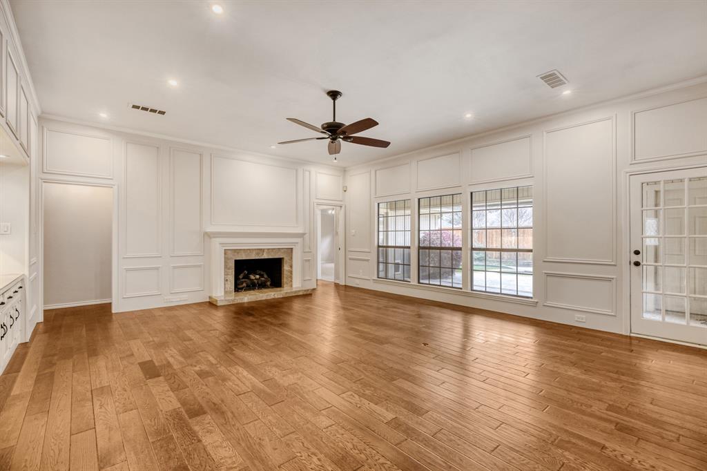 6108 Bluff Point Drive Dallas, TX 75248 - Photo 24 of 28 a view of an empty room with wooden floor and a fireplace