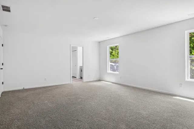 an empty room with windows and closet
