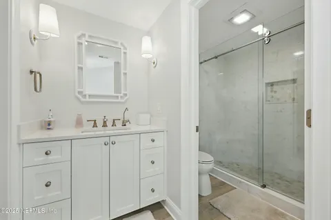 a bathroom with a granite countertop sink vanity and mirror