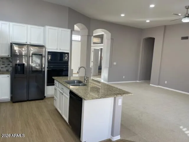 a kitchen with stainless steel appliances granite countertop a refrigerator a sink a stove and oven