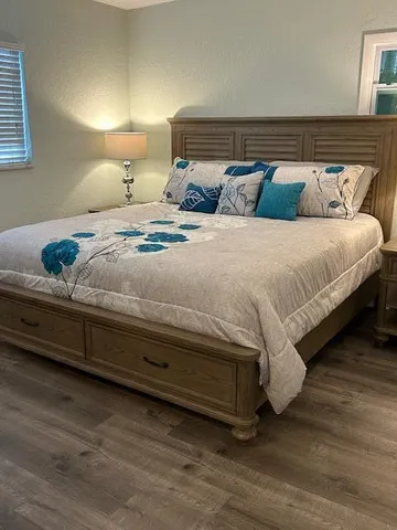 a bedroom with bed and wooden floor