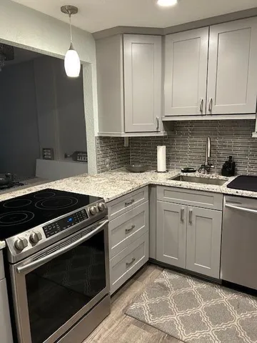 a kitchen with granite countertop cabinets stainless steel appliances and a sink