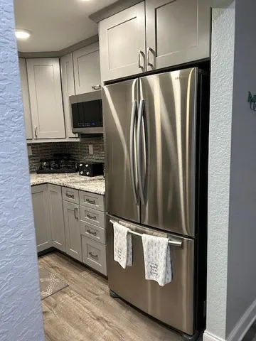 a kitchen with white cabinets and stainless steel appliances