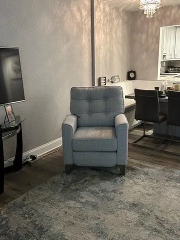 a living room with furniture a flat screen tv and a window