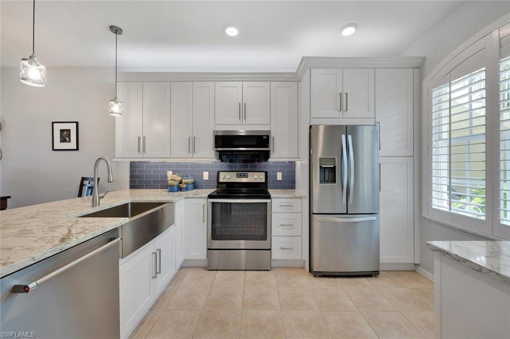 a kitchen with granite countertop a refrigerator oven a sink and dishwasher