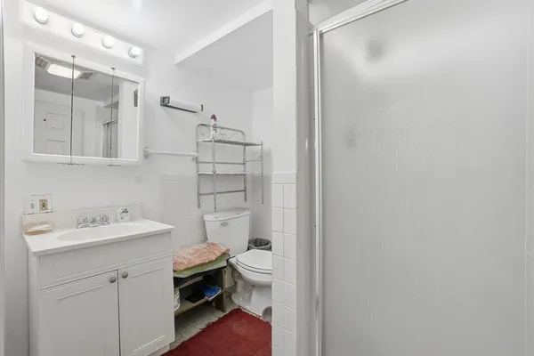 a bathroom with a sink a toilet a shower and a mirror