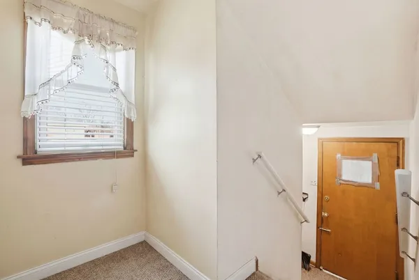 a view of front door with a white wall