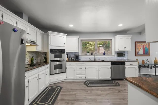 a kitchen with stainless steel appliances granite countertop a stove a sink and a refrigerator