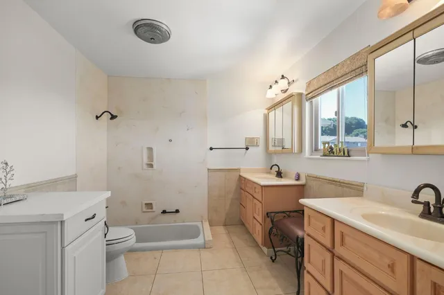 a bathroom with a granite countertop sink mirror vanity and toilet