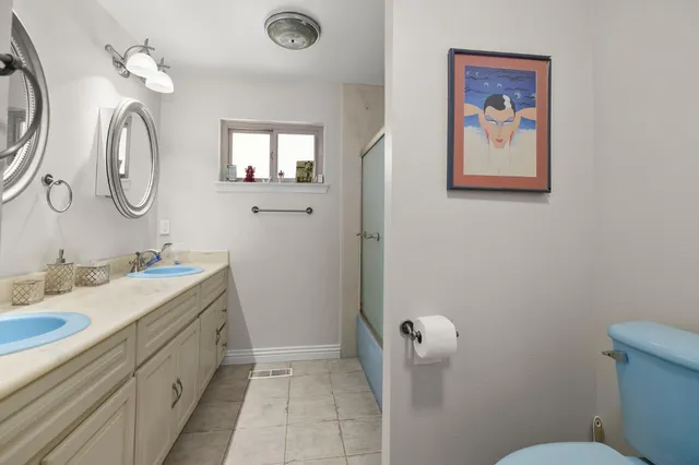 a bathroom with a double vanity sink and a mirror