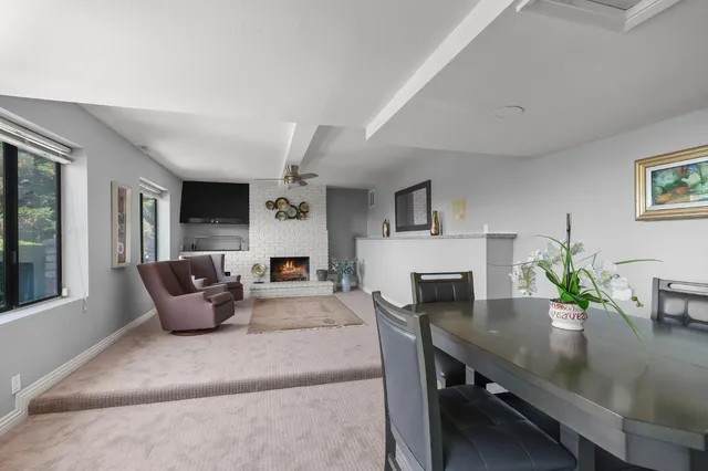a living room with furniture kitchen view and a potted plant