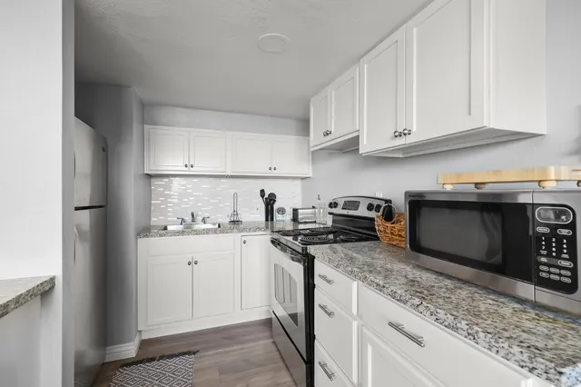a kitchen with stainless steel appliances granite countertop a stove a sink and a refrigerator
