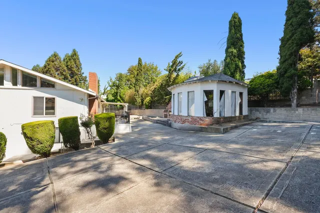 a view of a white house with a yard and plants