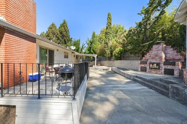 a view of a patio with table and chairs with wooden floor and fence