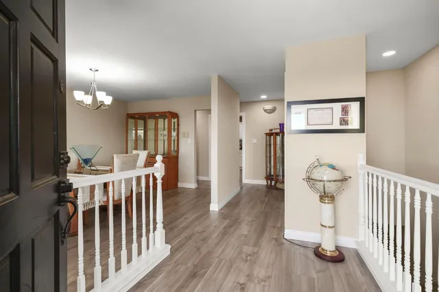 a view of a hallway with wooden floor and windows