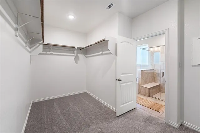 a view of an empty walk in closet and a bathroom
