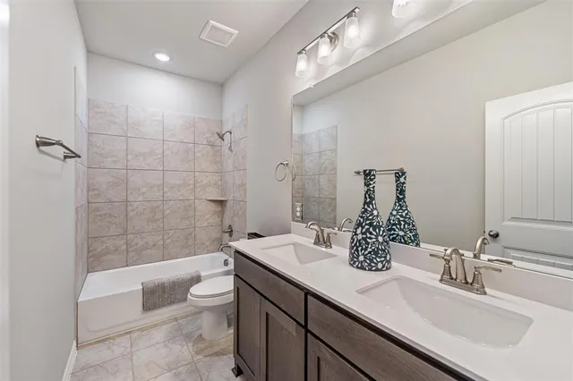 a bathroom with a double vanity sink toilet and shower