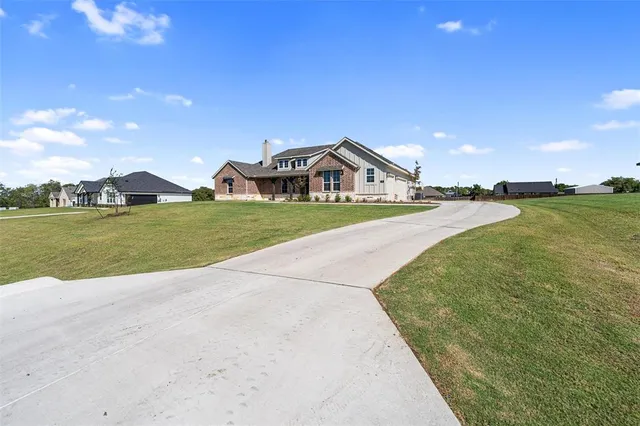 a view of a house with a yard and lake view