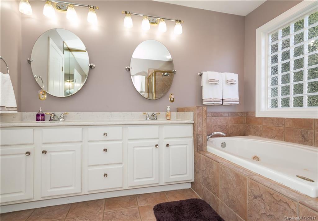 223 Beaten Path Road Mooresville, NC 28117 - Photo 12 of 24 a bathroom with a sink a mirror a vanity and a bathtub