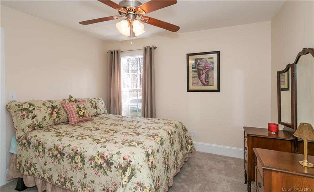 223 Beaten Path Road Mooresville, NC 28117 - Photo 14 of 24 a bedroom with a large bed and a chandelier