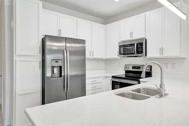 a kitchen with stainless steel appliances granite countertop a refrigerator stove a sink and microwave